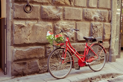 停在棕色砖墙旁的红色自行车